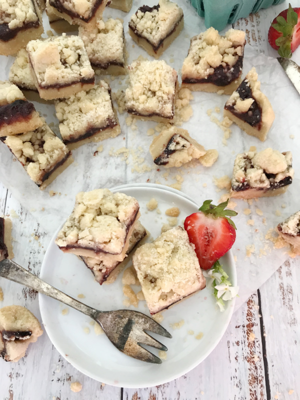 roasted strawberry bars on white plate with a red strawberry
