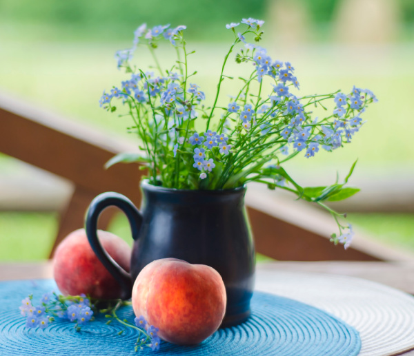 wildflowers in a brown pitcher and peaches