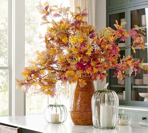 Cosy Fall Finds Pottery Barn Fall Branches in a base with clear glass pumpkins on a counter