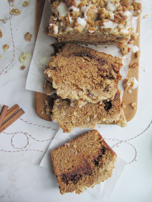 cinnamon swirl pumpkin bread with crumble topping on a wood cutting board sliced with cinnamon sticks and string-2