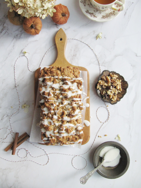 cinnamon swirl pumpkin bread with crumble topping on a wood cutting board