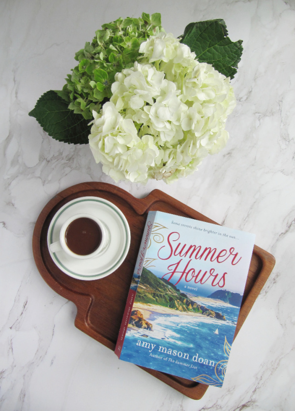 flatlay hydrangeas cup of hot chocolate and a book on a wood board