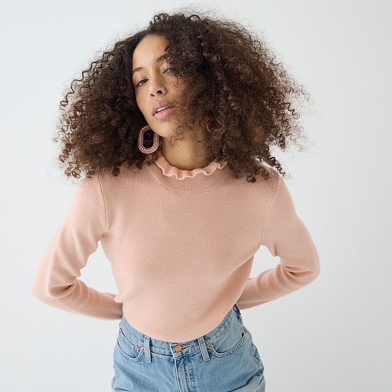 woman wearing a pink wool sweater and jeans