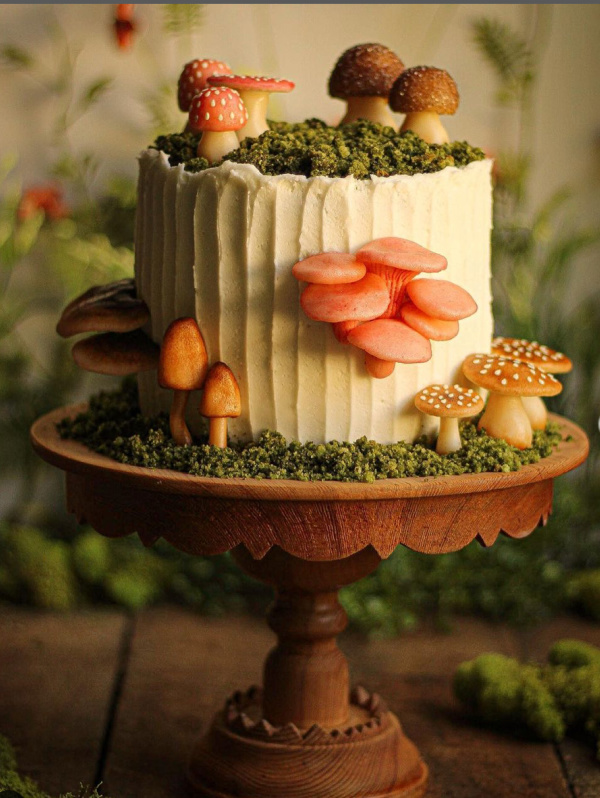 White cake covered in colorful marzipan mushrooms