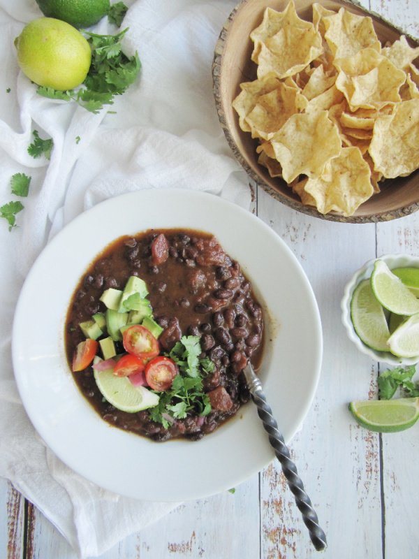 easy black bean soup one white bowl and wood bowl of scoops chips