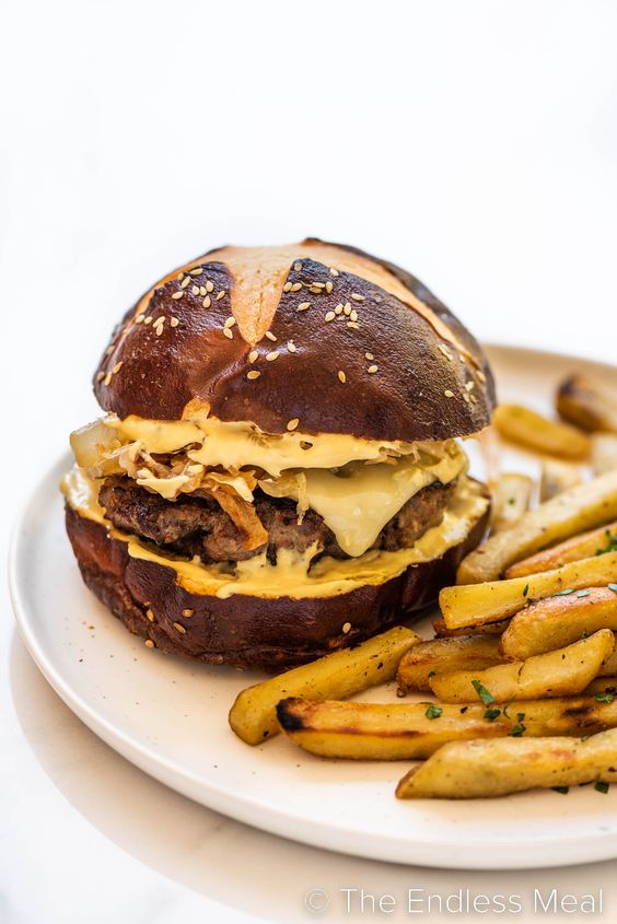 BRATWURST BURGER WITH ONION SAUERKRAUT TOPPING and French fries