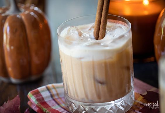 old fashioned glass with a pumpkin spice White Russian drink and a cinnamon stick. 