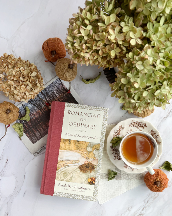 flatlay with dried hydragneas, cu of tea, and a book.