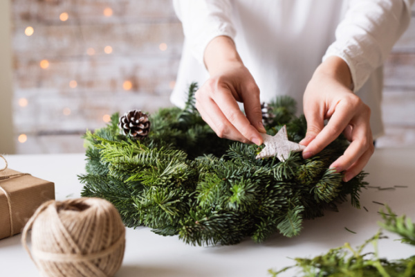 Ladies hands making a pine wreath.