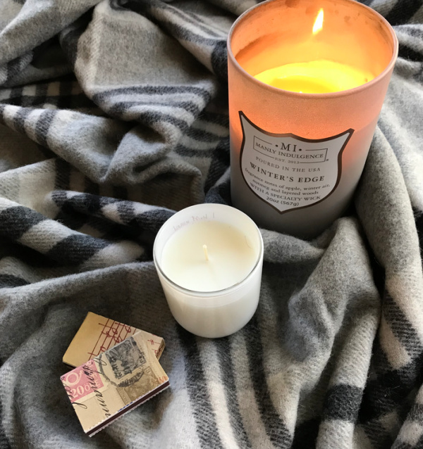 candle sitting on a plaid blanket