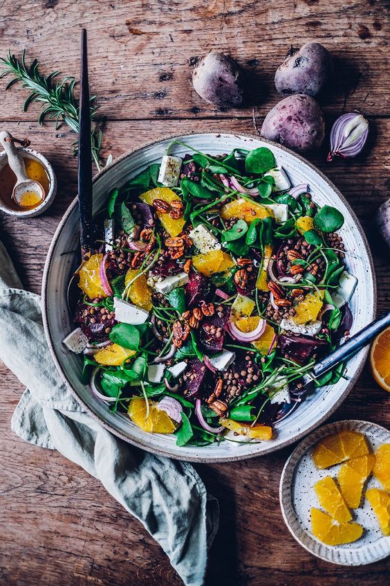 Wintry warm Beetroot Lentil Salad with Feta Cheese and Rosemary in a white bowl on a wood table.