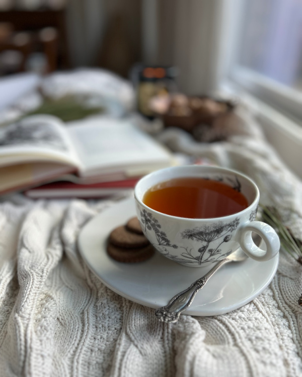 cup of tea on a cable knit blanket.