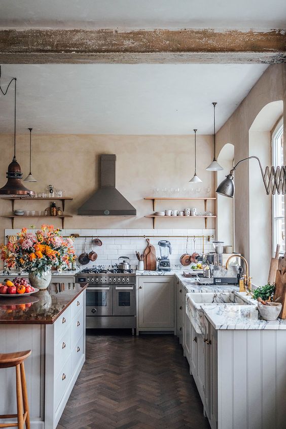 White kitchen with copper island stainless hood. 