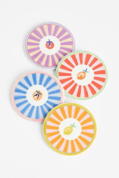 Colorful plates, 4 with fruit in the center. 