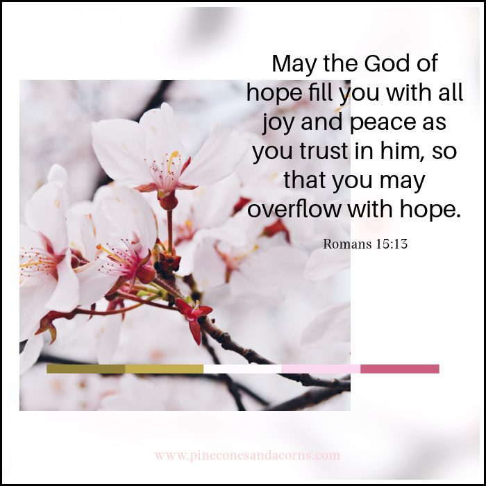 Quote May the God of hope fill you with all joy and peace as you trust in home, so that you may overflow with hope overlay on an image with cherry blossoms.