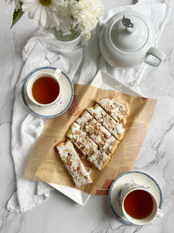 almond puff pastry swedish Kringle with 2 cups of coffee and a pot of tea.