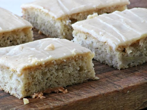 Banana Bars with Browned Butter Glaze sliced on a wood cutting board.