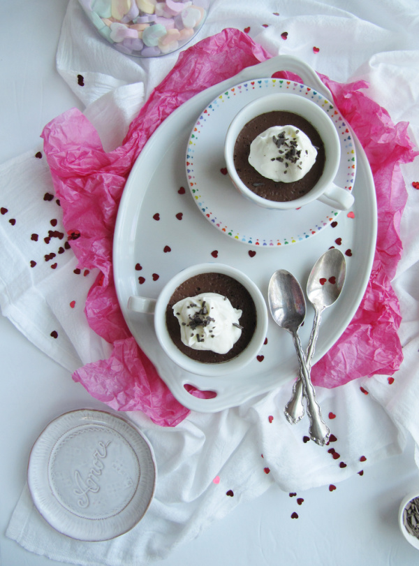 Vegan Chocolate Ganache Mousse in wo white cups with colorful hearts on a white tray.