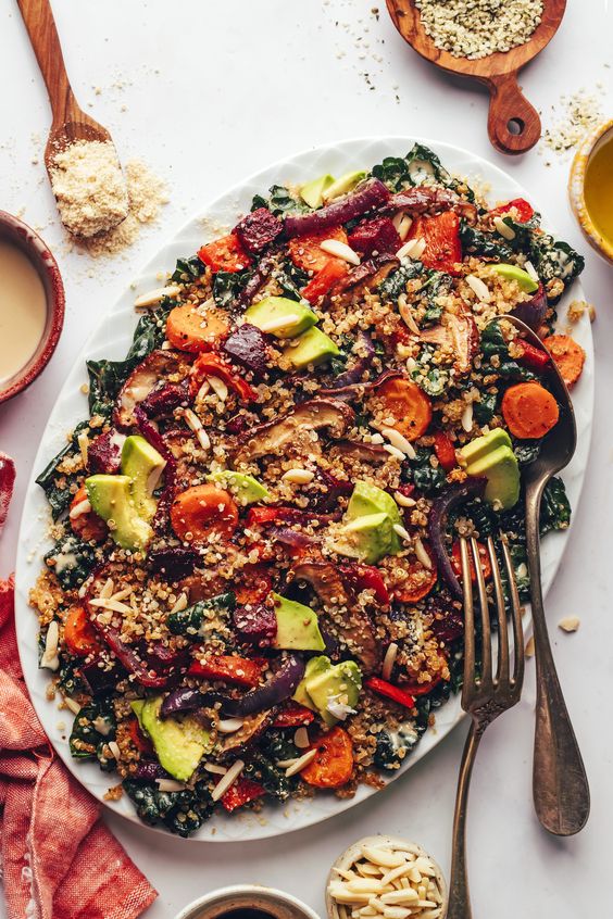  Crispy Quinoa & Roasted Vegetable Kale Salad on a white platter. 