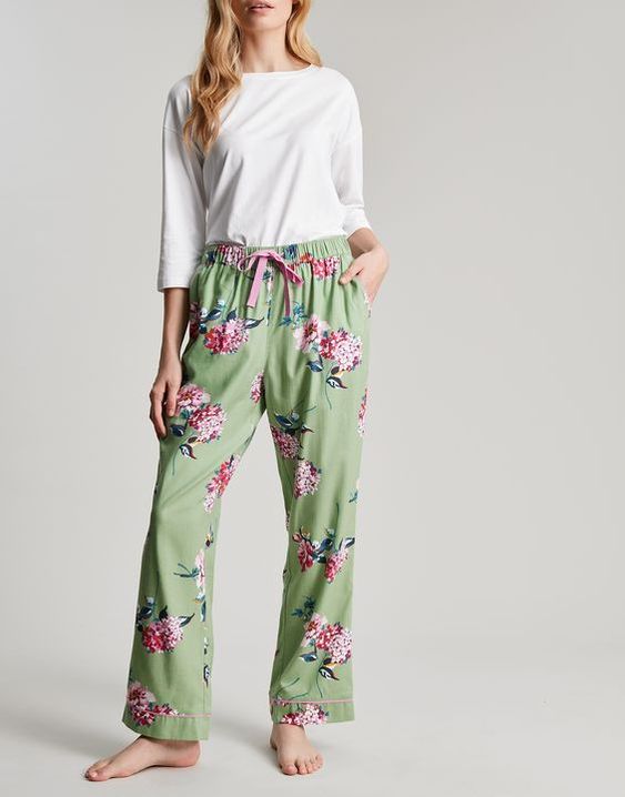 woman wearing a white shirt and green flower pajamas. 