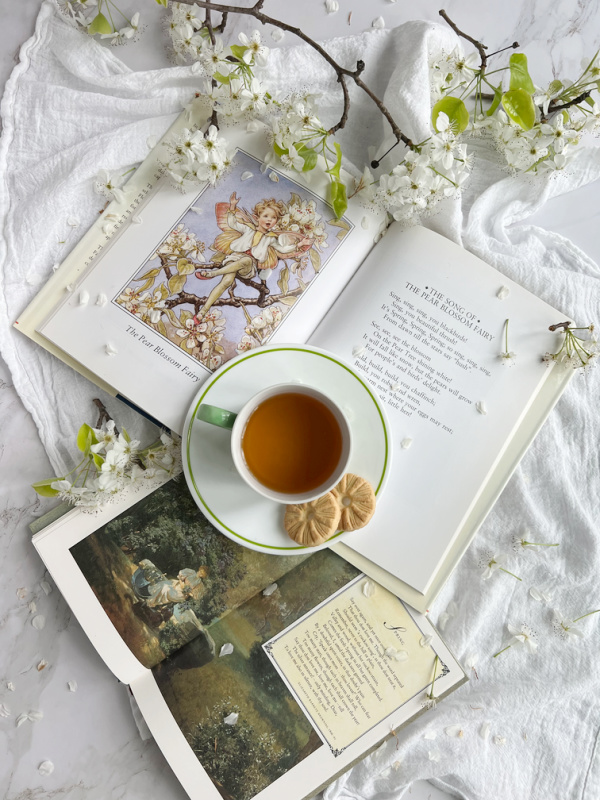Spring flatlay with pear blossoms, books and tea.