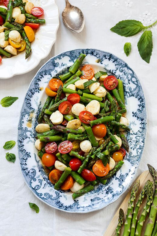 Blue and white transferware platter with an asparagus and tomato salad. 