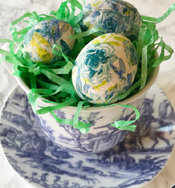 green and blue eggs in a blue and white tea cup.
