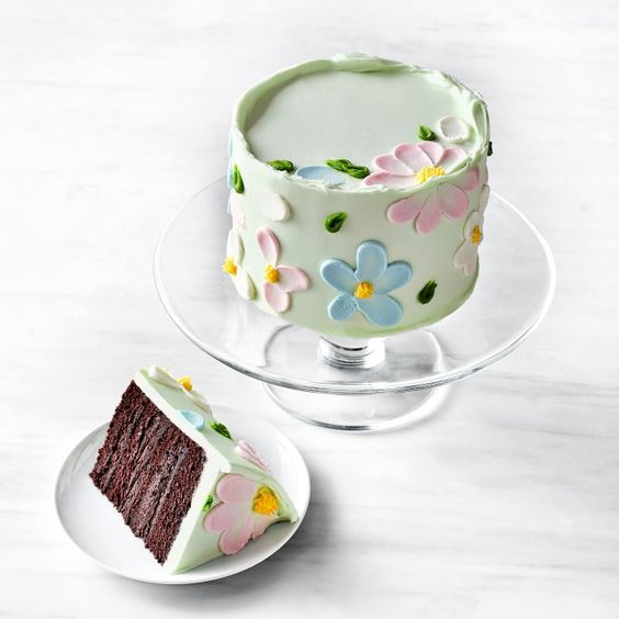 Pale blue frosted chocolate cake with colorful pastel flowers. 