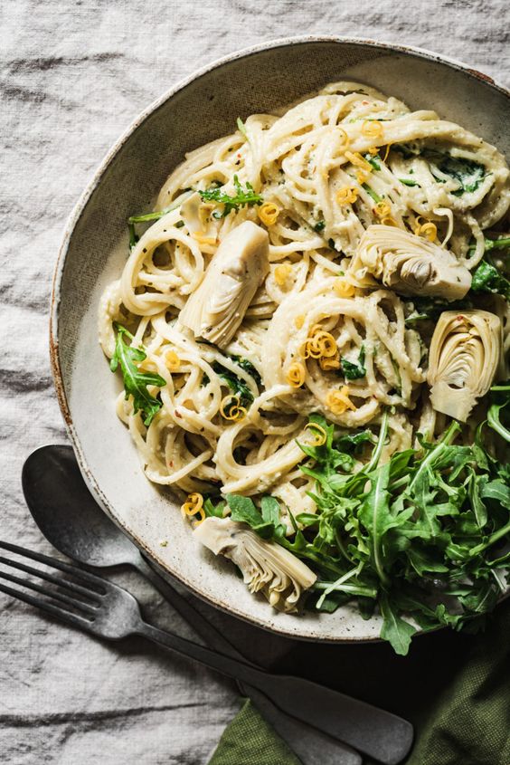 ARTICHOKE LEMON PESTO PASTA in a tan bowl.