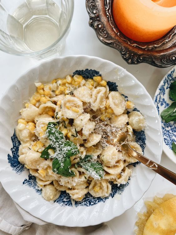 CREAMY ORECCHIETTE WITH CORN AND BASIL in a blue and white bowl. 