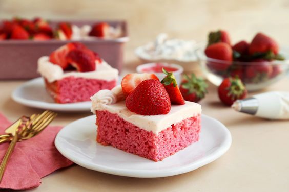 strawberry cake with cream cheese frosting on a white plate. 