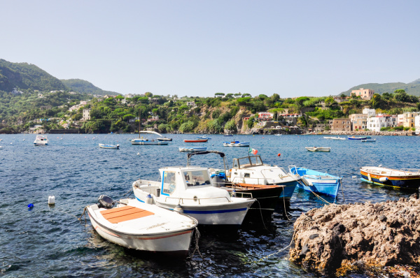 Italian coast with small boats bobbin in the water.