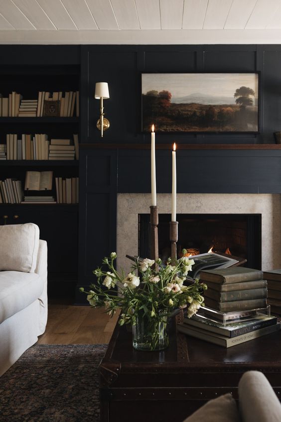 A dark blue living room with a fireplace and 2 bookcases flanking the fireplace. 