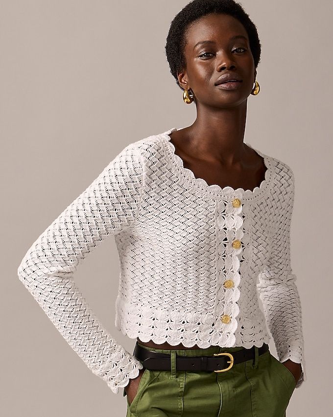 Woman wearing a white crochet sweater and pants. 