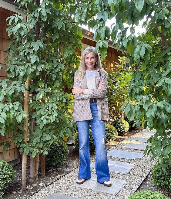 Woman wearing jeans and a tweed blazer. 