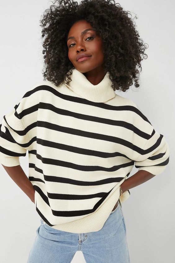 Woman wearing a black and white stripe turtleneck sweater.