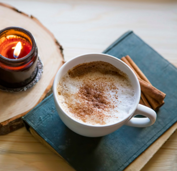 Monday musings cup of cocoa with cinnamon on a book and a candle