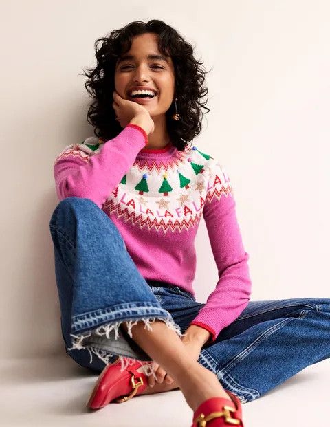 woman wearing a pink fa la la la la fair isle sweater from Boden. 