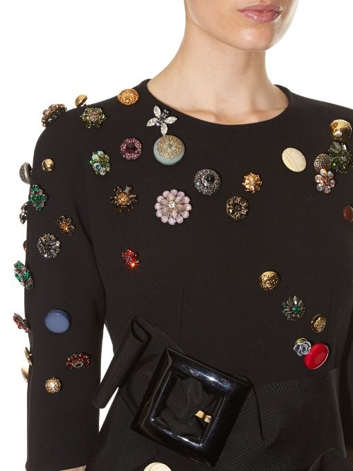 A black sweater with brooches all over it. 