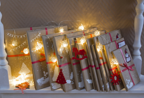 advent-calendar of books wrapped in brown paper with fairy lights.