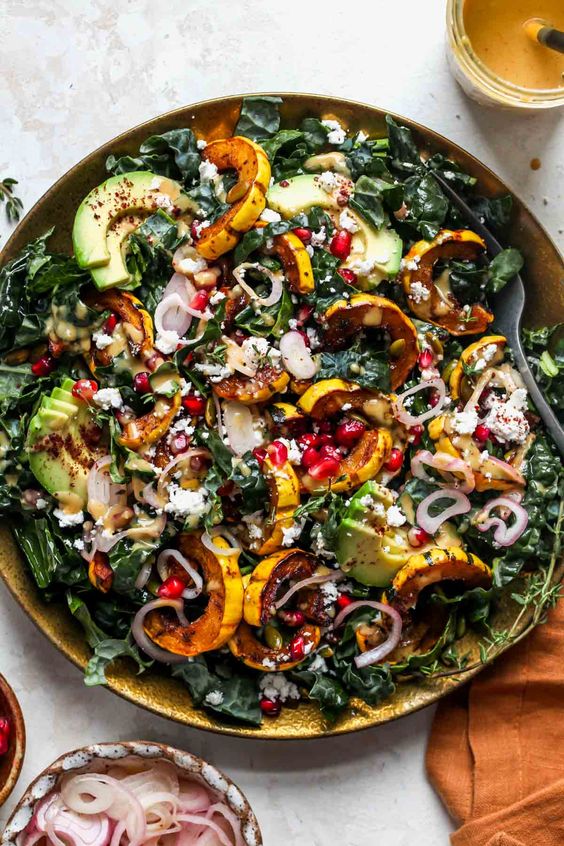 Autumn Delicata Squash Salad with sweet and spicy roasted squash, crisp greens, avocado, and pomegranate tossed in a lively maple-mustard dressing.