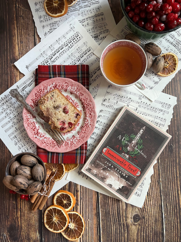 Friday Favorites flatlay with cup of tea book sheet music and cranberry bread on red transfer ware.