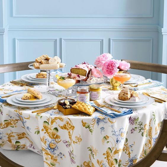 a blue room with a beautiful romantic tablescape with flowers, tea, scones.