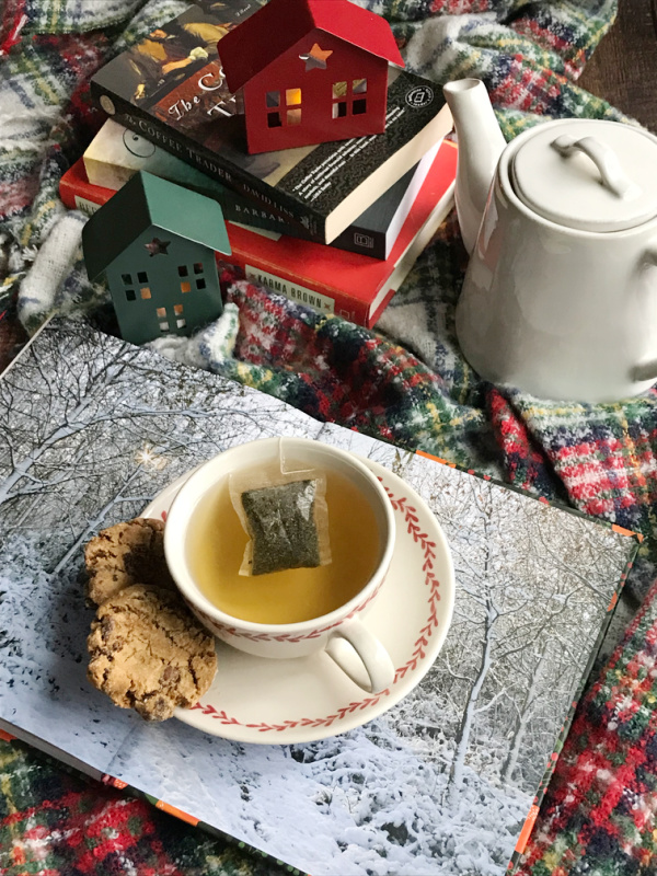 Friday Favorites Flatlay with tea cookies, books and a tea post on a plaid throw.