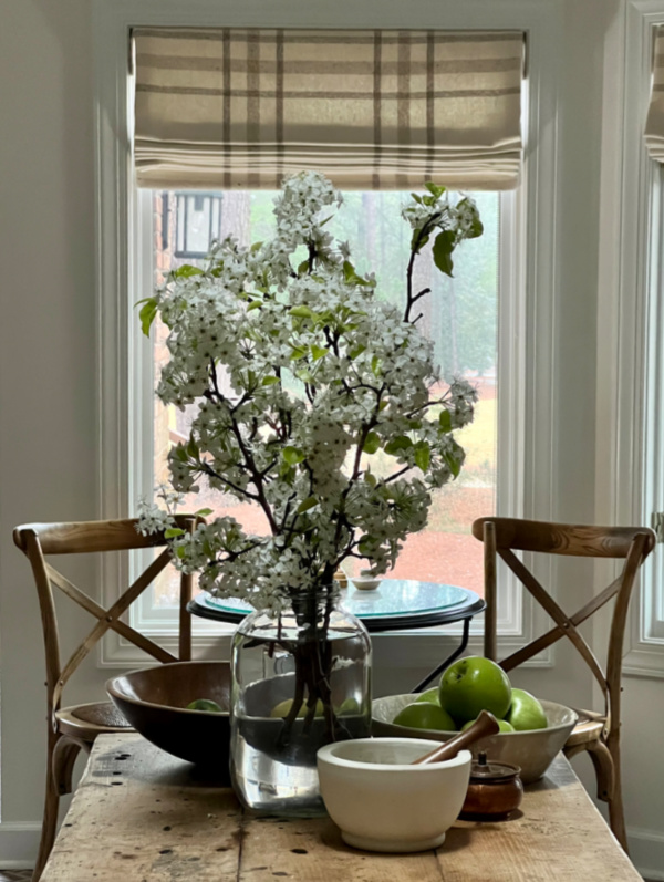 Pear Blossoms in a large jar on an island in the kitchen.