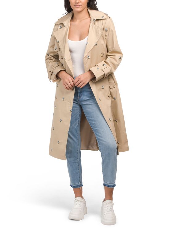 Tan trench coat with embroidered flowers. 