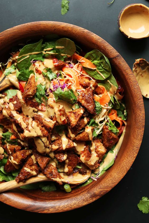 Thai Salad with Peanut Tempeh in a brown wood bowl. 