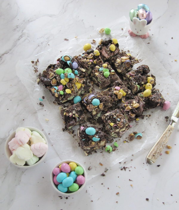 Rocky Road Candy with M & M's and three little bowls of marshmallows, candy and a little bunny with easter eggs.