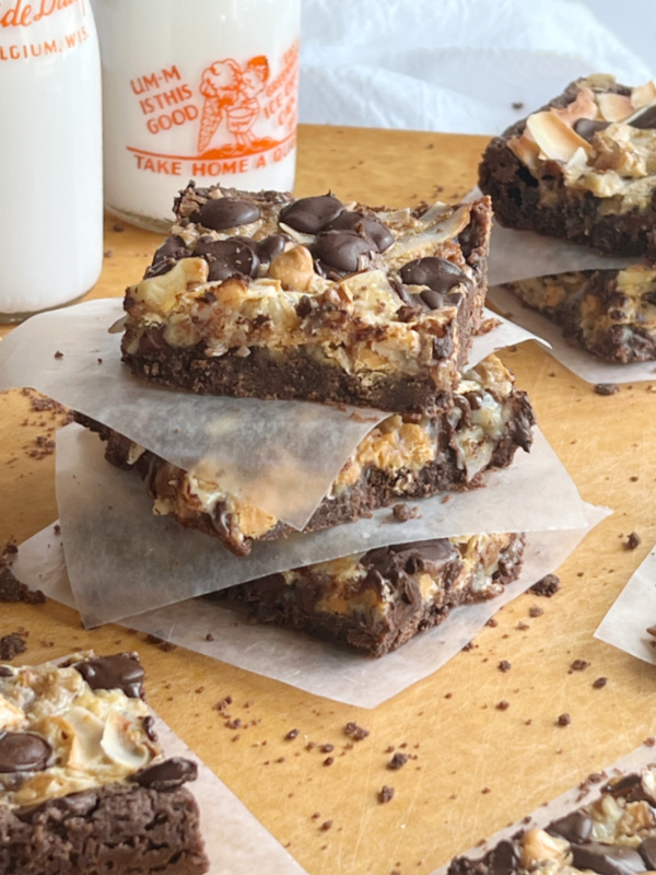 Ghirardelli Seven Layer Brownie Bar Recipe with 2 vintage milk bottles filled with milk.