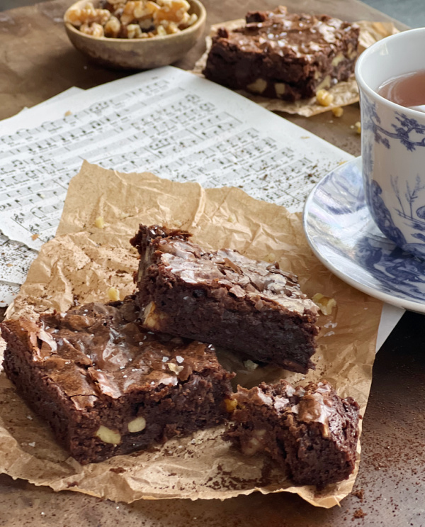 Ina Outrageous Brownies with walnuts and a blue and white toile cup and saucer of tea. 